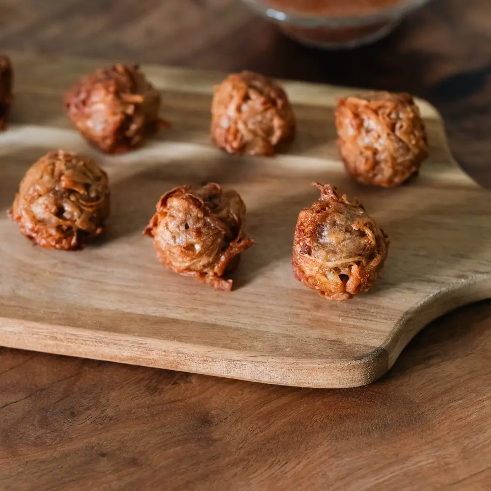 Golden fried gato arouille arranged on a wooden board