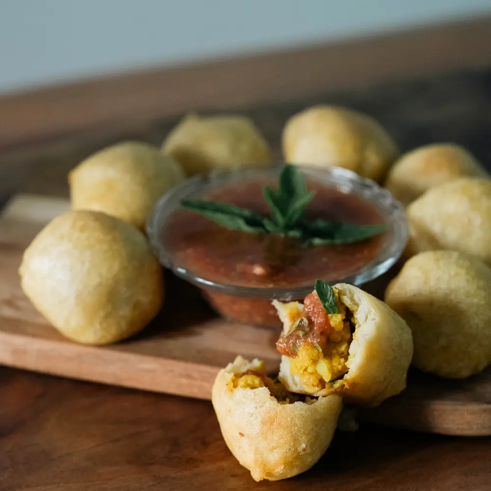 Golden chana puri, one broken open to show the spiced chickpea filling